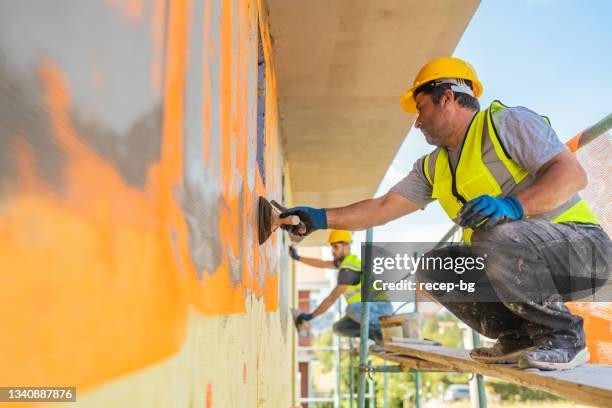 Stucco contractor applying finish to exterior wall in New York
